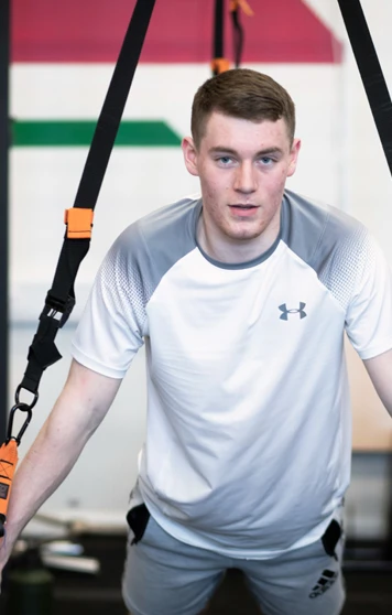 Focused man performing suspension push-ups with TRX straps. Focused man performing suspension push-ups with TRX straps.